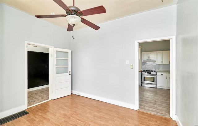 unfurnished room with baseboards, ceiling fan, visible vents, and light wood finished floors