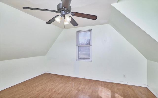 bonus room featuring baseboards, lofted ceiling, wood finished floors, and a ceiling fan