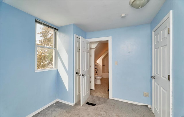 unfurnished bedroom with baseboards, carpet flooring, and visible vents