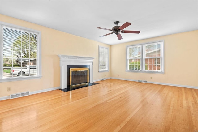 unfurnished living room featuring plenty of natural light, visible vents, and wood finished floors