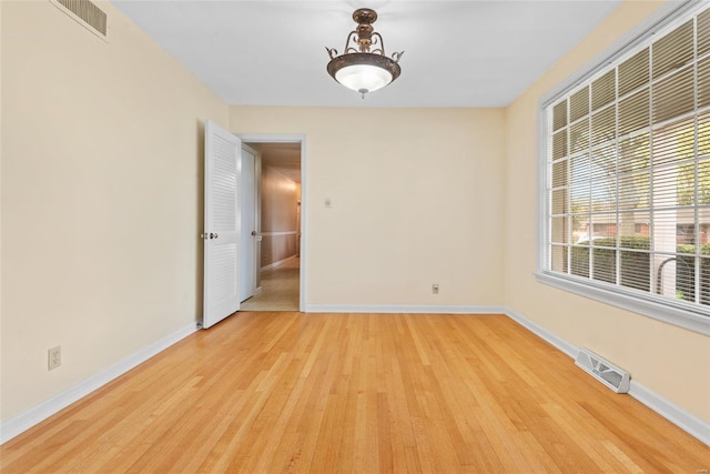 unfurnished room with visible vents, baseboards, and light wood finished floors
