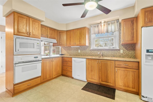 kitchen featuring a sink, ceiling fan, white appliances, under cabinet range hood, and decorative backsplash