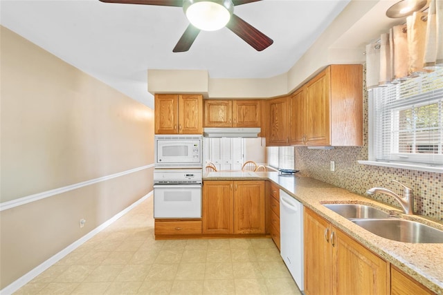 kitchen with baseboards, a sink, ceiling fan, white appliances, and decorative backsplash