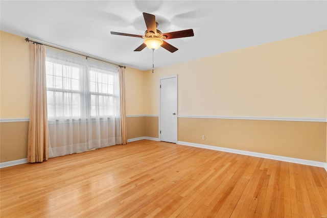 unfurnished room featuring light wood-style flooring, a ceiling fan, and baseboards