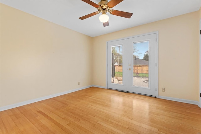 empty room featuring light wood-style flooring, baseboards, and french doors