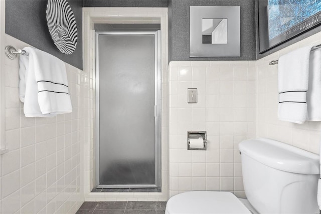 full bathroom with a shower stall, tile walls, and toilet