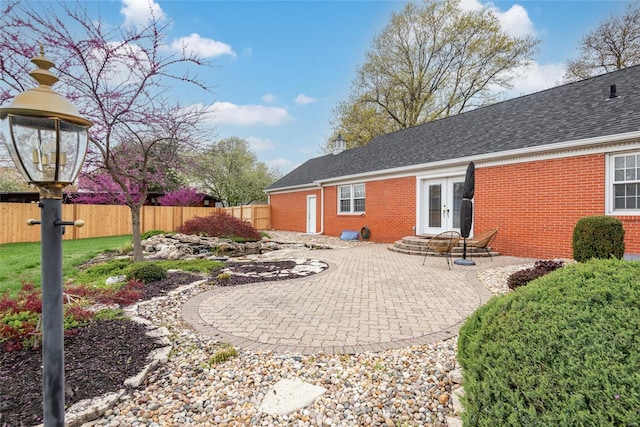 back of property with french doors, fence, and brick siding