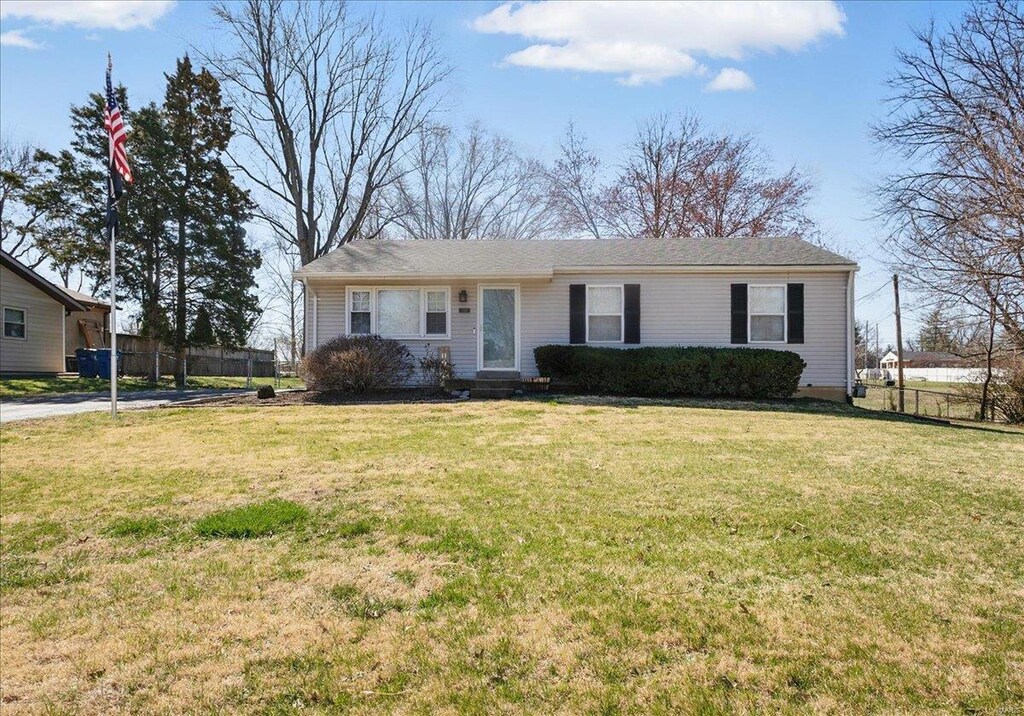 ranch-style house featuring a front yard and fence