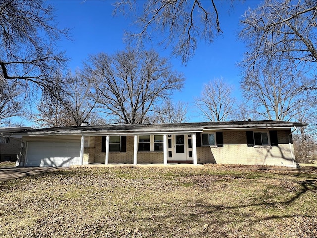 single story home featuring driveway, brick siding, and an attached garage