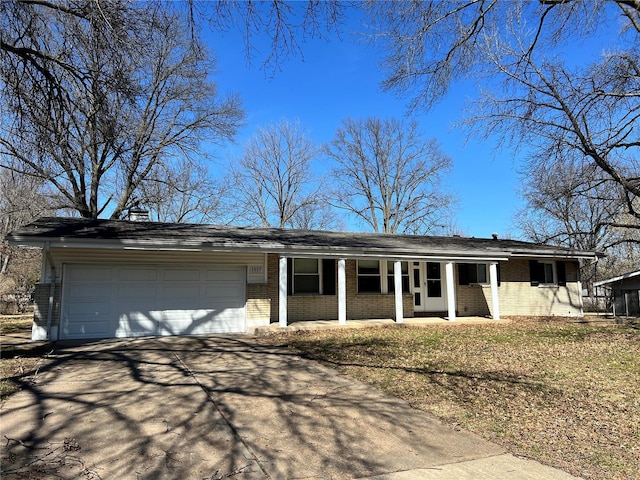 ranch-style house with a porch, brick siding, a garage, and driveway
