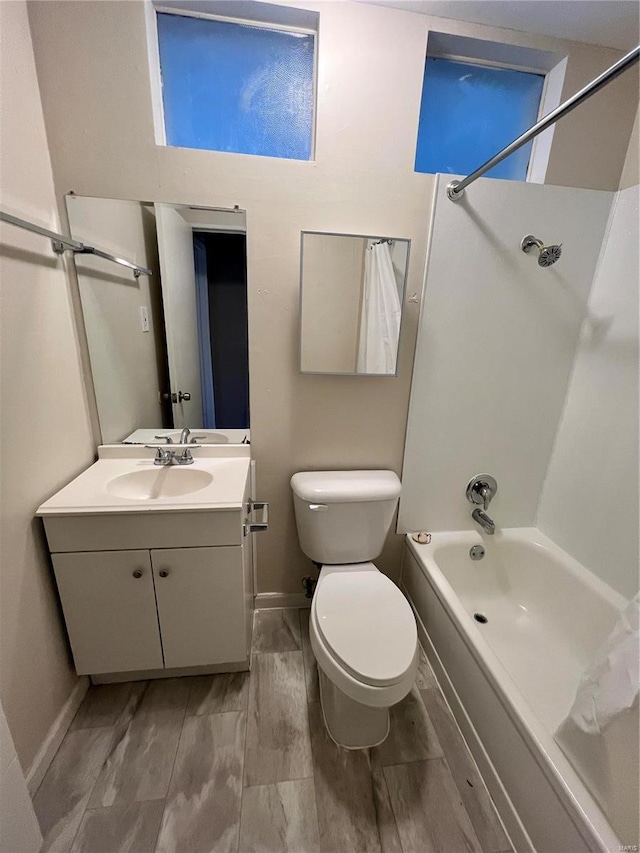 full bath featuring vanity,  shower combination, toilet, and baseboards