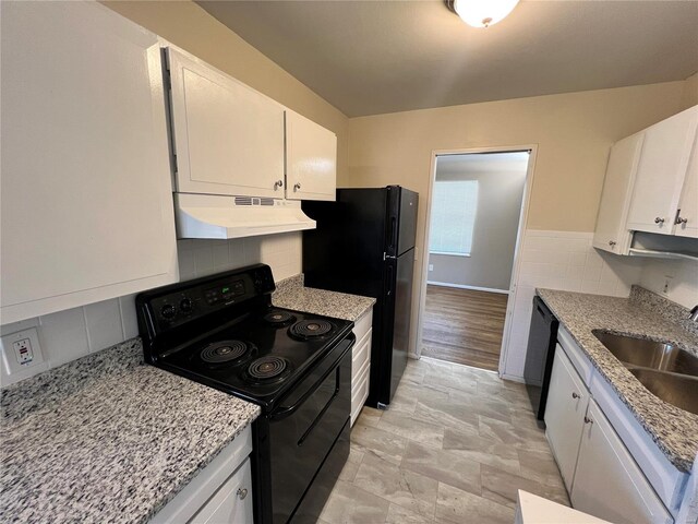 kitchen featuring under cabinet range hood, black appliances, white cabinets, and a sink
