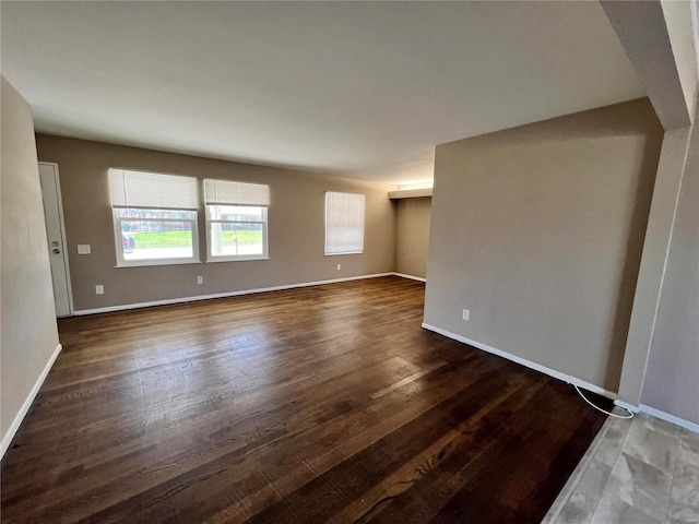 empty room featuring dark wood finished floors and baseboards