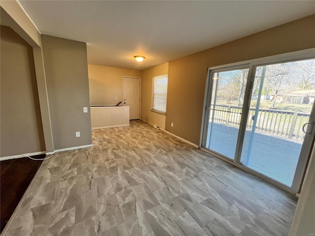 unfurnished room with baseboards