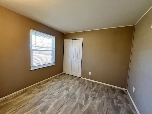 unfurnished bedroom with a closet and baseboards