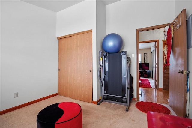 exercise room featuring baseboards and carpet floors