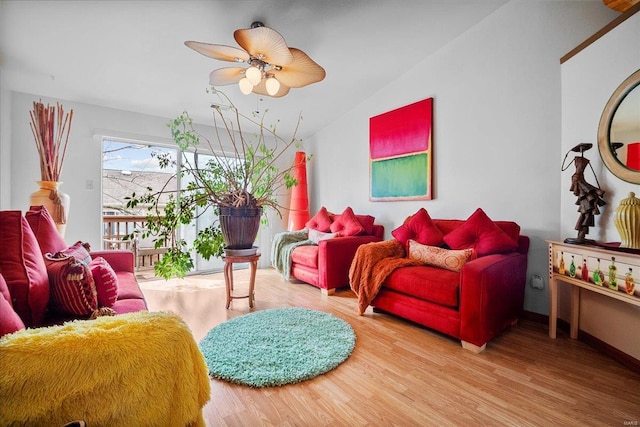 living room with wood finished floors, ceiling fan, and vaulted ceiling