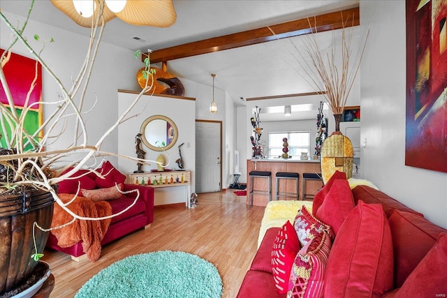 living area with wood finished floors, ceiling fan, and lofted ceiling with beams