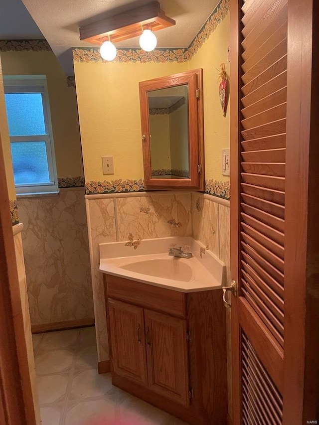 bathroom with vanity, tile walls, and wainscoting