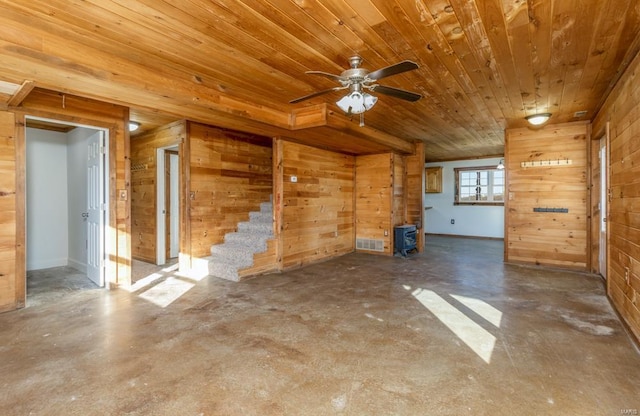 unfurnished living room with wood walls, wood ceiling, concrete flooring, and a ceiling fan