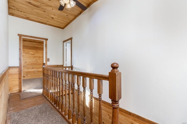 hall with an upstairs landing and wooden ceiling
