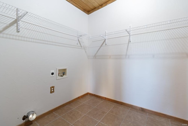 laundry area featuring laundry area, electric dryer hookup, tile patterned flooring, wooden ceiling, and baseboards