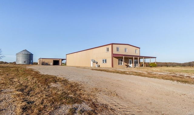 exterior space with an outbuilding, a detached garage, and dirt driveway