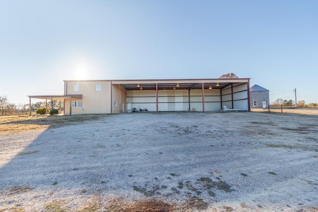exterior space featuring a detached carport and dirt driveway