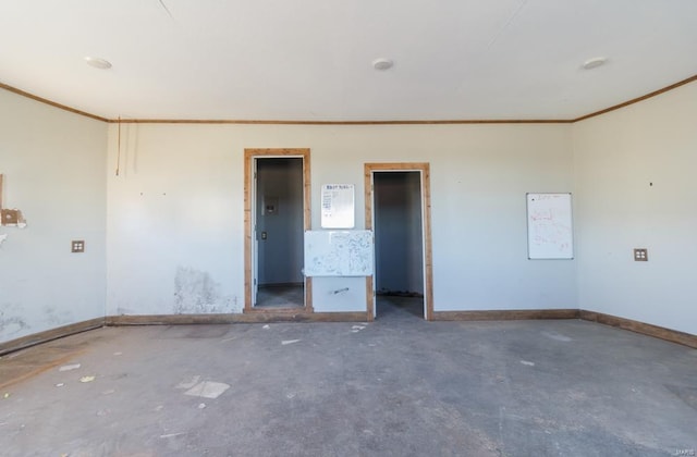 spare room with crown molding, concrete floors, and baseboards