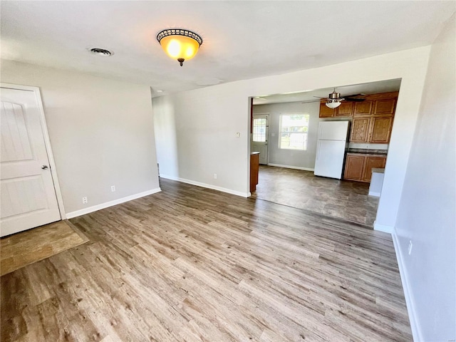 interior space featuring wood finished floors, baseboards, a ceiling fan, and visible vents