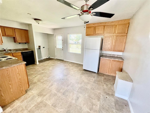 kitchen with a ceiling fan, a sink, baseboards, black dishwasher, and freestanding refrigerator