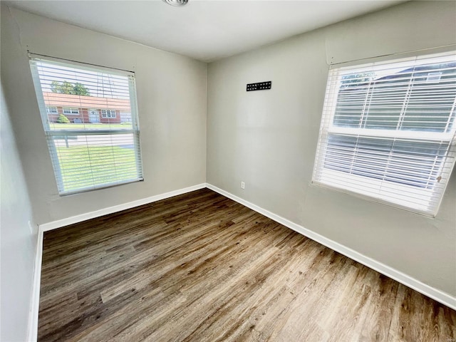 unfurnished room featuring baseboards and wood finished floors