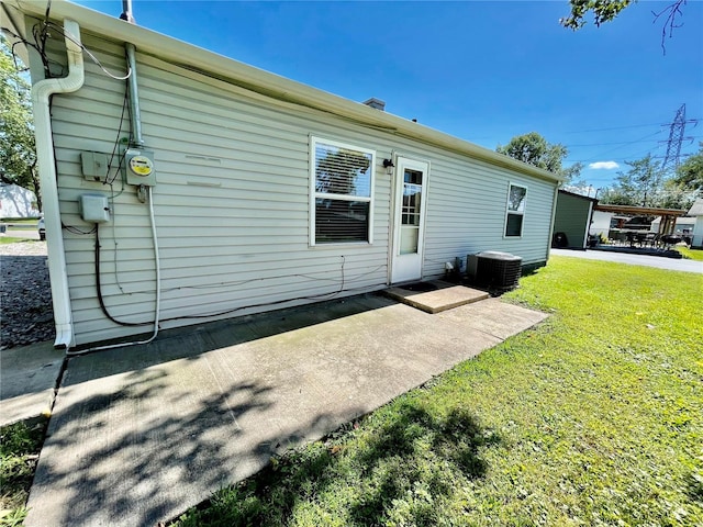 rear view of house with a lawn, a patio area, and central AC