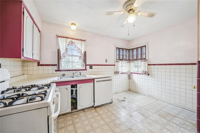 kitchen with tile walls, white appliances, light countertops, and a sink
