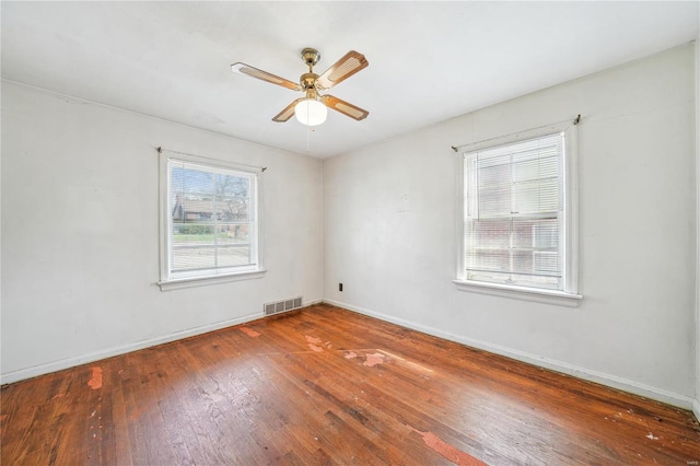 spare room with visible vents, baseboards, a ceiling fan, and hardwood / wood-style flooring