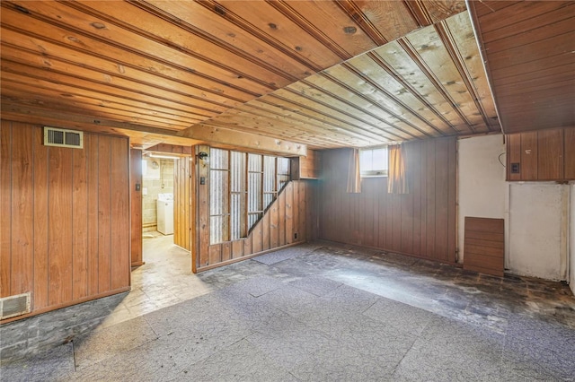 below grade area with washer / clothes dryer, wooden ceiling, wood walls, and visible vents