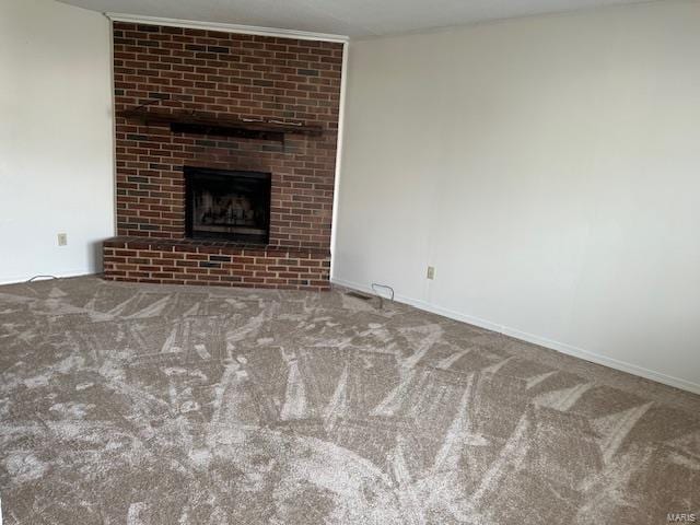 unfurnished living room with a brick fireplace, carpet flooring, and baseboards
