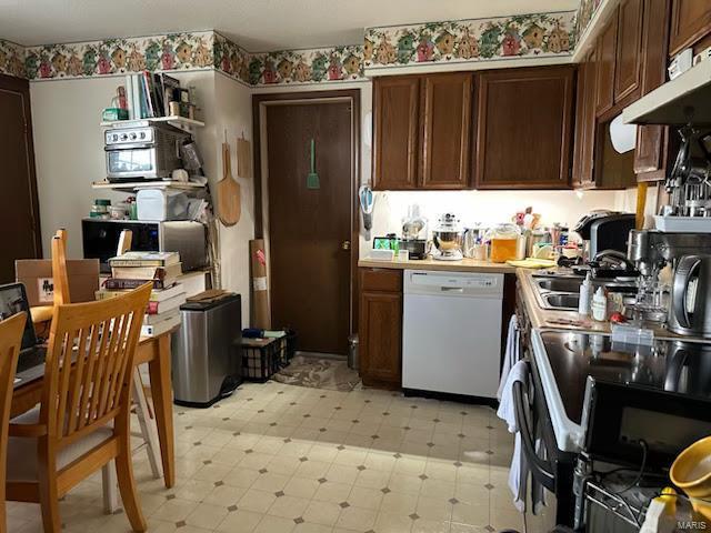 kitchen featuring black electric range, a sink, light countertops, light floors, and dishwasher