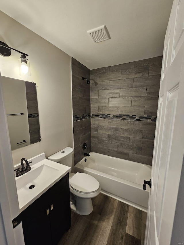 bathroom with visible vents, toilet, shower / tub combination, wood finished floors, and vanity