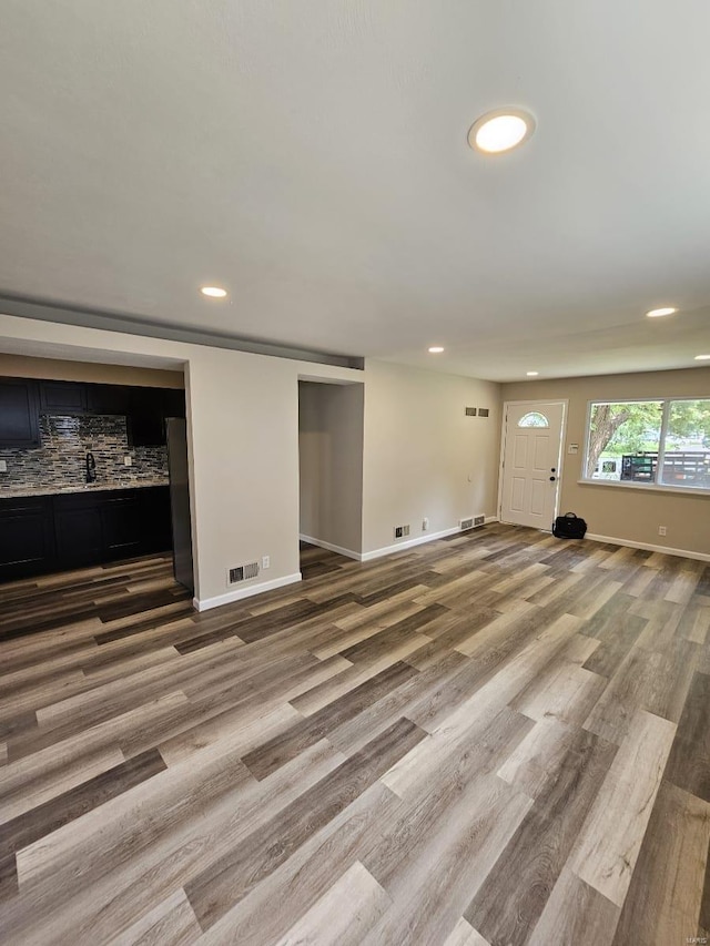 unfurnished living room featuring recessed lighting, wood finished floors, and visible vents