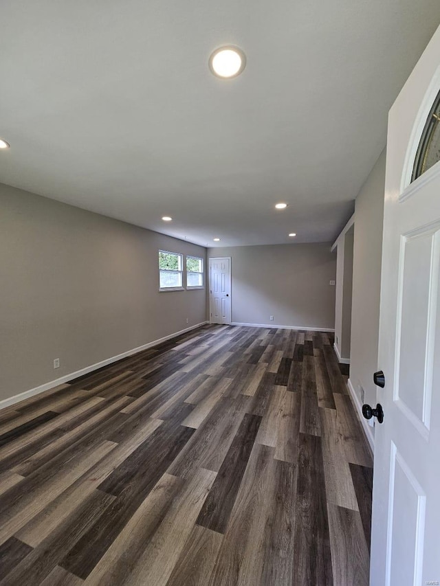 spare room with recessed lighting, baseboards, and dark wood finished floors