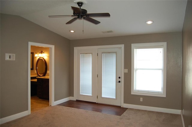 entryway featuring vaulted ceiling, baseboards, visible vents, and carpet floors