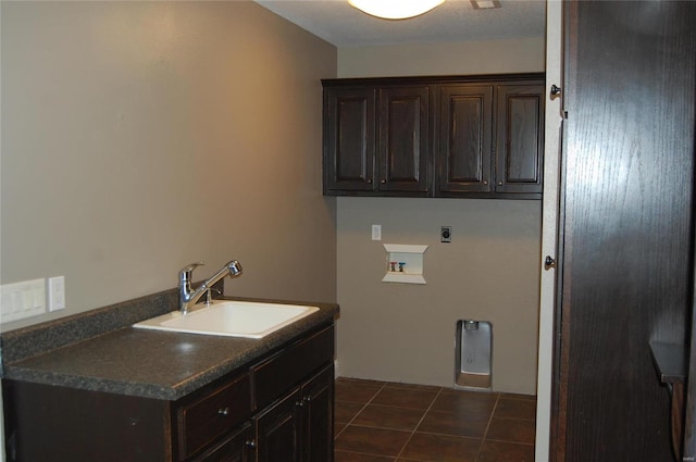 laundry area featuring hookup for a washing machine, cabinet space, electric dryer hookup, a sink, and dark tile patterned floors