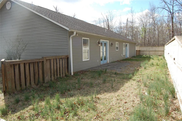 rear view of house with french doors, a patio area, a shingled roof, and fence