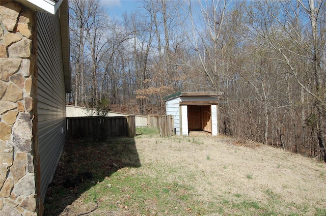 view of yard with a storage unit, an outdoor structure, and fence