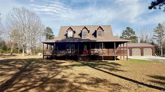 view of front of house with an outbuilding, a porch, and driveway
