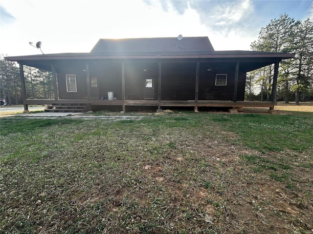 rear view of house featuring a yard and covered porch