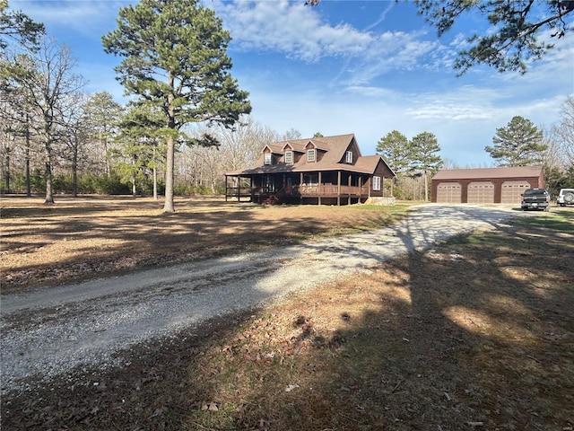 view of front of home with a garage, an outbuilding, and dirt driveway