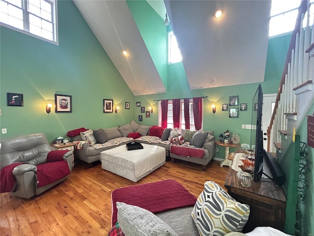 living room featuring a high ceiling, wood finished floors, and a wealth of natural light