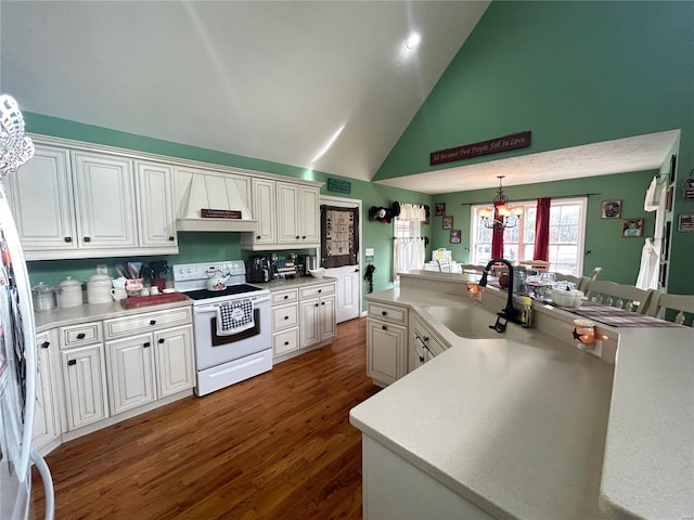 kitchen featuring a sink, light countertops, custom range hood, electric stove, and a notable chandelier